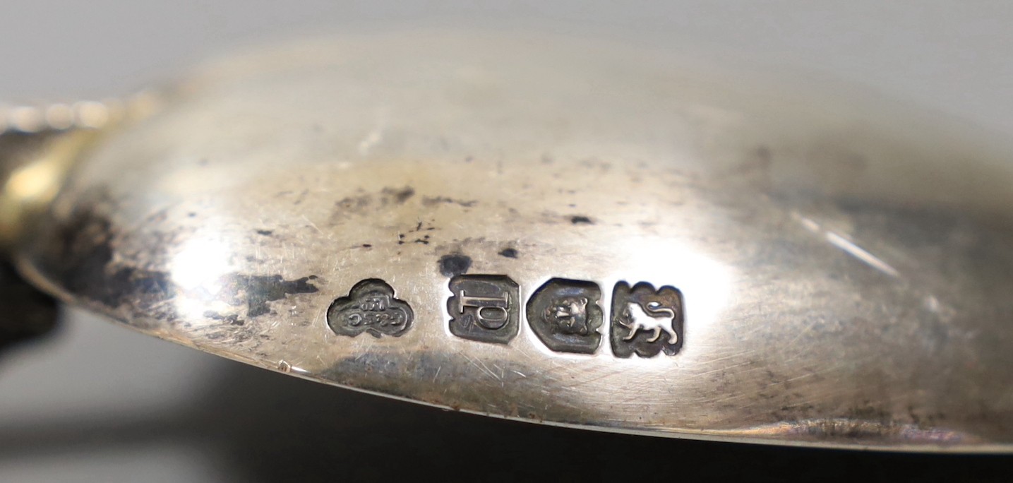 A pair of George III silver grape scissors, by Eley & Fearn, London, 1818 and a George V silver replica of the anointing spoon, Goldsmiths & Silversmiths Co Ltd, London 1910, 166 grams.